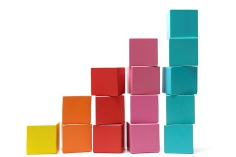 Putting the final building block onto the top of a rising pile signifying success and achievement.