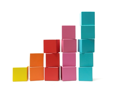 Putting the final building block onto the top of a rising pile signifying success and achievement.